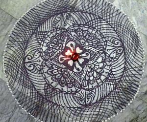 A freehand rangoli with recycled dark blue colour.