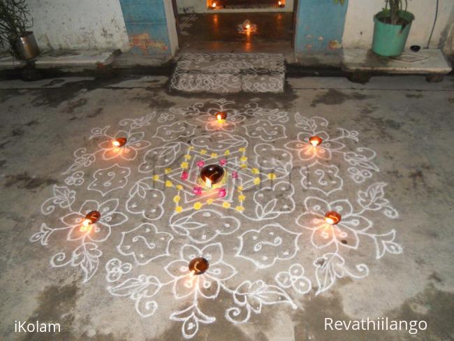 Rangoli: Karthigai kolam in white with deepam & flowers.