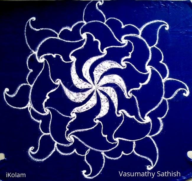 Rangoli: White swirling flower- a freehand rangoli with kolamavu on a blue plastic cover.