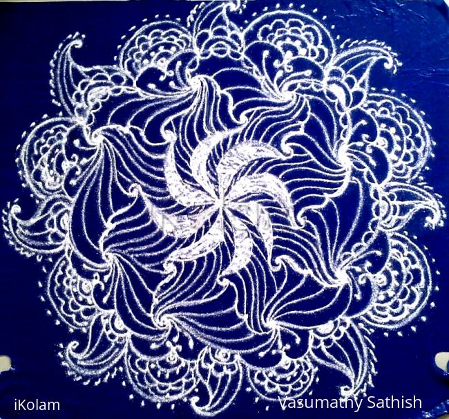 Rangoli: White swirling flower- a freehand rangoli with kolamavu on a blue plastic cover.